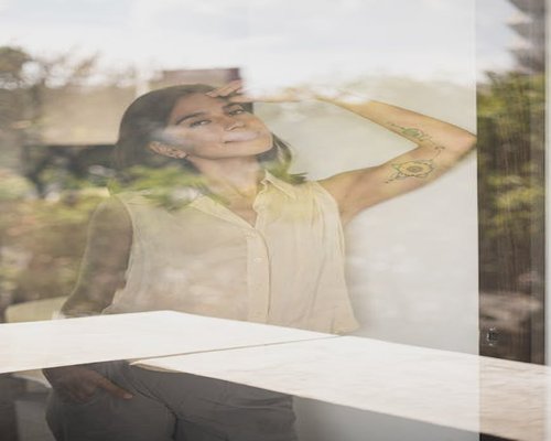 Colombian woman looking out of the window to rest her eyes during work